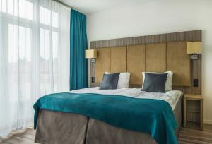 a large bed in a room with a large window at Hotel Oxelösund in Oxelösund