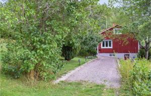 a red barn with a gravel road in front of it at Nice Home In Gamleby With House A Panoramic View in Gamleby
