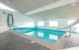 SaltumにあるBeautiful Home In Saltum With 5 Bedrooms, Wifi And Indoor Swimming Poolの青いプール付きの建物内のスイミングプール