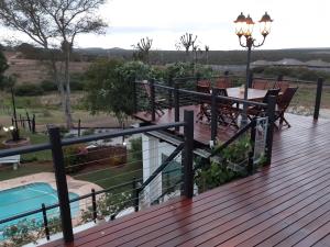 a wooden deck with a table and chairs on it at Little Tree loft 2 in Uitenhage