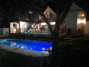 Uitenhage的住宿－Little Tree loft 2，夜间在房子前面的游泳池