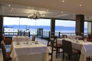 a restaurant with tables and chairs with a view of the ocean at Hotel Las Dunas in El Calafate