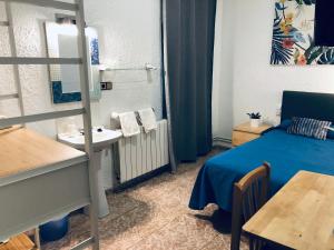 a small room with a bed and a sink at Hostal Carlos III in El Prat de Llobregat
