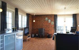 BjerregårdにあるStunning Home In Hvide Sande With Kitchenのレンガの壁のリビングルーム(テレビ付)