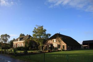 een huis met een zwart dak en een grasveld bij De Aze in Terwolde