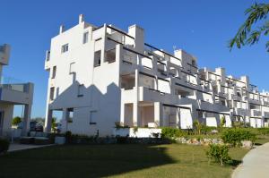 Un bâtiment blanc avec beaucoup de fenêtres dans l'établissement Hilly's Place, à Roldán