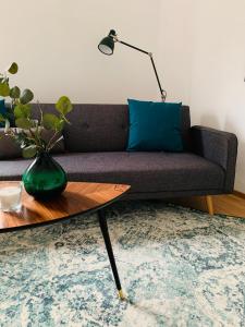 a living room with a couch with a blue pillow and a table at Danilos Boardinghouse in Weinheim