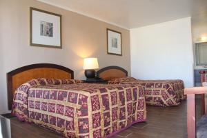 Postel nebo postele na pokoji v ubytování LoneStar Inn and Suites