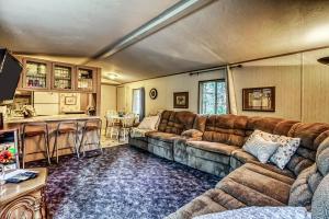 a living room with a large couch and a kitchen at Pinecone Den in Leavenworth