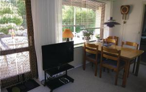 a dining room with a table and a television at Awesome Home In Rnne With 2 Bedrooms And Wifi in Rønne