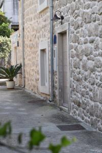 um edifício de pedra com uma porta e uma planta ao lado em Charming Stone House in Cavtat Old Town em Cavtat