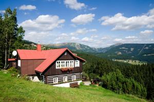 ein Haus auf einem Hügel mit rotem Dach in der Unterkunft Pension Skalicky in Pec pod Sněžkou