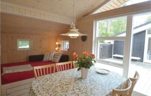 a dining room with a table and a bedroom at Three-Bedroom Holiday Home In Vaggerlose in Marielyst