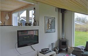 HaslevgårdeにあるNice Home In Hadsund With 3 Bedrooms, Sauna And Wifiのリビングルーム(薄型テレビ、コンロ付)
