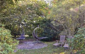 ティスヴィレライにあるAmazing Home In Tisvildeleje With Kitchenの庭園内の椅子2脚とベンチ