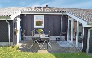 HaslevgårdeにあるNice Home In Hadsund With 3 Bedrooms, Sauna And Wifiの家の前のパティオ(テーブル付)