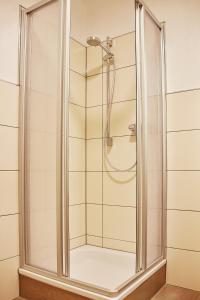 a shower with a glass door in a bathroom at Joos Hotel in Bergheim