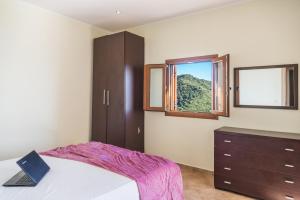 1 dormitorio con 1 cama con ordenador portátil en Villa Belle Plaza, en Vitalades