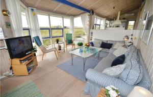 a living room with a couch and a tv at Holiday Home Harrietsvej in Grønhøj +12 photos