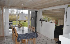HaslevgårdeにあるNice Home In Hadsund With 3 Bedrooms, Sauna And Wifiのキッチン、ダイニングルーム(テーブル、椅子付)