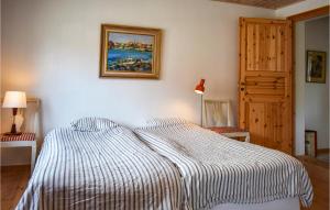 ein Schlafzimmer mit einem Bett mit einer gestreiften Decke in der Unterkunft Amazing Home In Ystad With Kitchen in Ystad