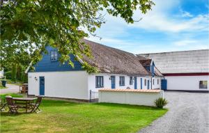 ein weißes Haus mit einem blauen Dach und einem Picknicktisch in der Unterkunft Amazing Home In Ystad With Kitchen in Ystad