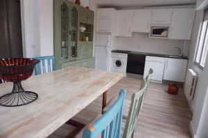 une cuisine avec une table et des chaises en bois dans l'établissement Casa La Solana, à Bolaños de Campos