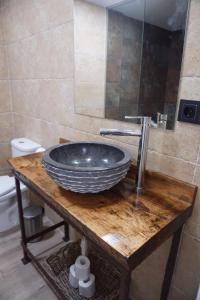 a bathroom with a bowl sink on a wooden table at Casa La Solana in Bolaños de Campos