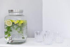 a jar filled with water with lemon slices and glasses at Hotel Miceli - Civico 50 in Florence