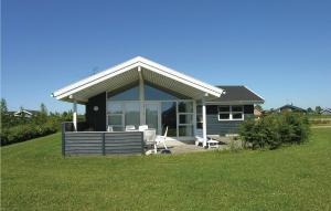 a small house with a porch and a lawn at Holiday Home Strandparken in Otterup