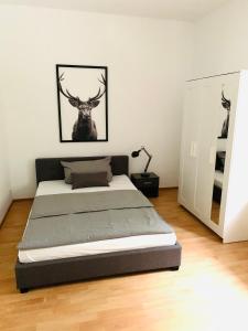 a bedroom with a bed with a deer picture on the wall at Danilos Boardinghouse in Weinheim