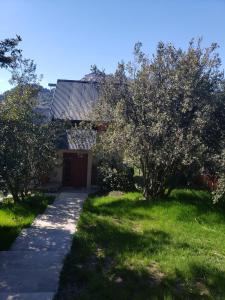 a house with a garden with trees and a sidewalk at MAKAVIZA in Villa Pehuenia