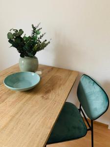 drewniany stół z płytką i rośliną w obiekcie Danilos Boardinghouse w mieście Weinheim