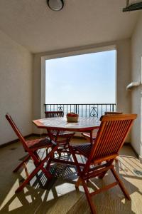 a table and chairs in a room with a large window at Apartments Leut in Sveti Stefan