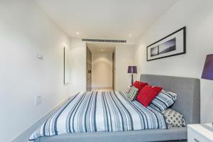 ロンドンにあるChelsea - Executive Apartmentのベッドルーム1室(赤い枕のベッド1台付)