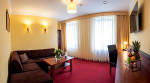 a living room with a couch and a table at Hotel Piotr Spa&Wellness in Boguszów-Gorce