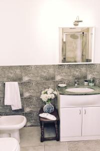 a bathroom with a sink and a toilet and a mirror at Rosa Garden B&B in Mestre