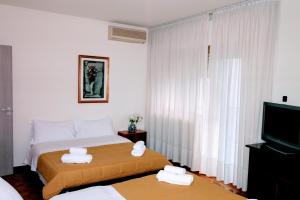 een hotelkamer met een bed en een televisie bij Rosa Garden B&B in Mestre