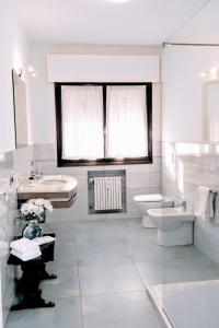 a white bathroom with a sink and a toilet at Rosa Garden B&B in Mestre