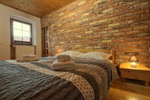 ミウクフにあるApartament w Karkonoszachのレンガの壁とベッドが備わるベッドルーム1室が備わります。