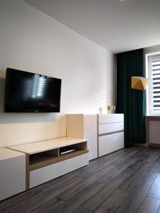 een woonkamer met een flatscreen-tv aan de muur bij Apartament Skandynawski Sienkiewicza 13 in Kielce