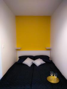 a bedroom with a bed with two glasses on it at Apartament Skandynawski Sienkiewicza 13 in Kielce