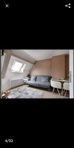 - une chambre mansardée avec un lit et une table dans l'établissement Cosy village, à Bonneuil-en-France