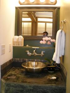 a bathroom with a sink and a mirror at Secret Garden Inn in San Diego