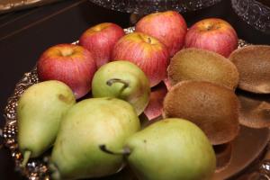 einen Stapel Äpfel und andere Früchte auf einem Teller in der Unterkunft Casa Vittoria Napoli - Santa Lucia in Neapel