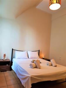 Schlafzimmer mit einem Bett mit weißer Bettwäsche und Kissen in der Unterkunft House with yard Subway 5min walk in Athen