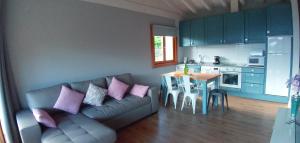 ein Wohnzimmer mit einem Sofa und einem Tisch sowie eine Küche in der Unterkunft El Mirador de Bodes in Bodes