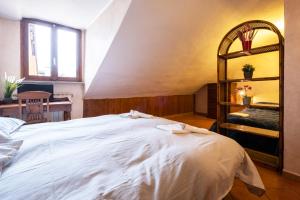 een slaapkamer met een groot wit bed en een spiegel bij Mansarda xx settembre 72 in Turijn