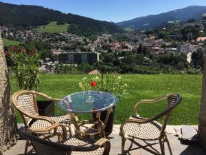 einen Glastisch und zwei Stühle mit Stadtblick in der Unterkunft Lambach Villa in Mürzzuschlag