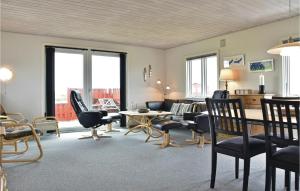 HavrvigにあるNice Home In Hvide Sande With 3 Bedrooms And Wifiのリビングルーム(テーブル、椅子付)、